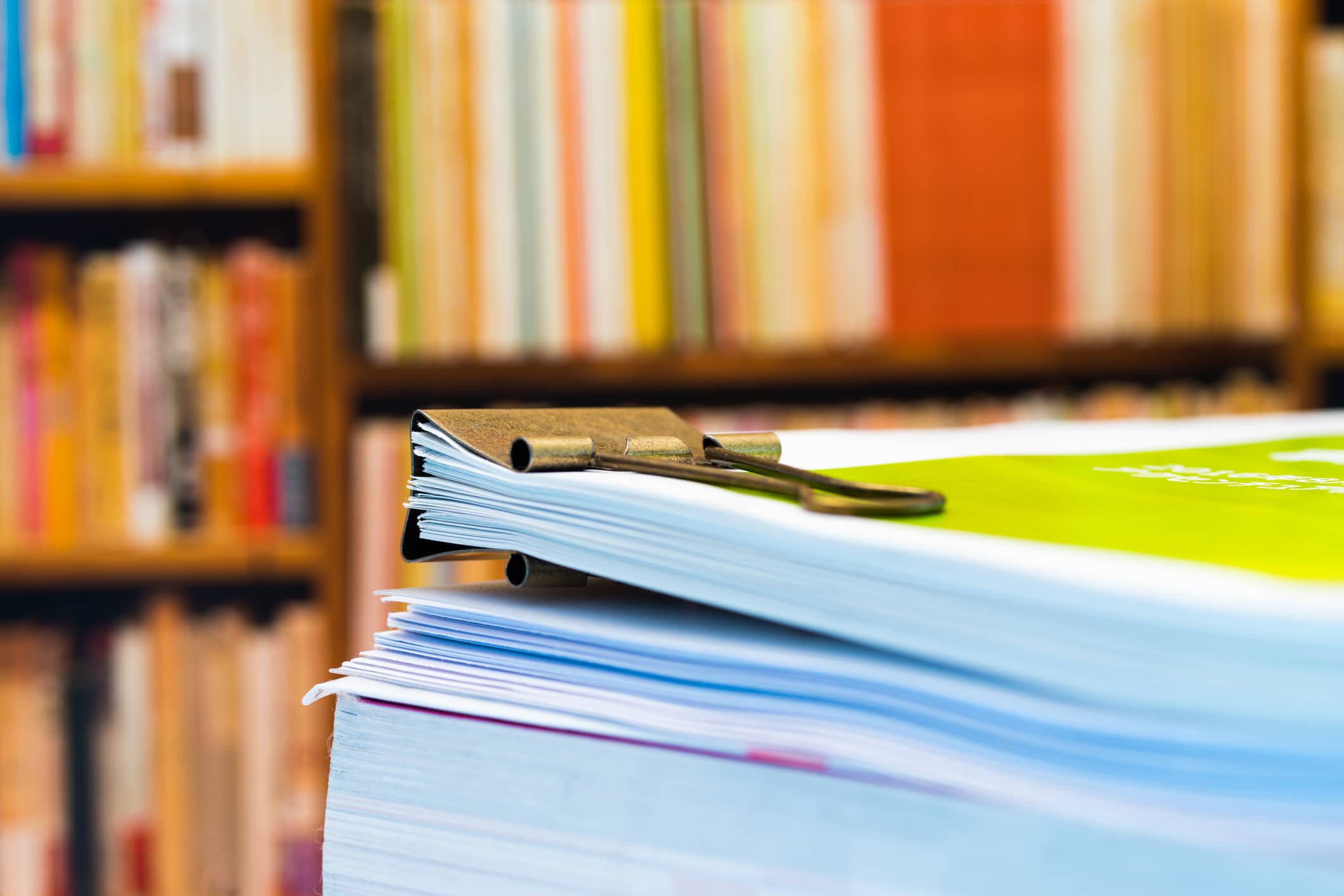 Piles of paper on background of book shelf